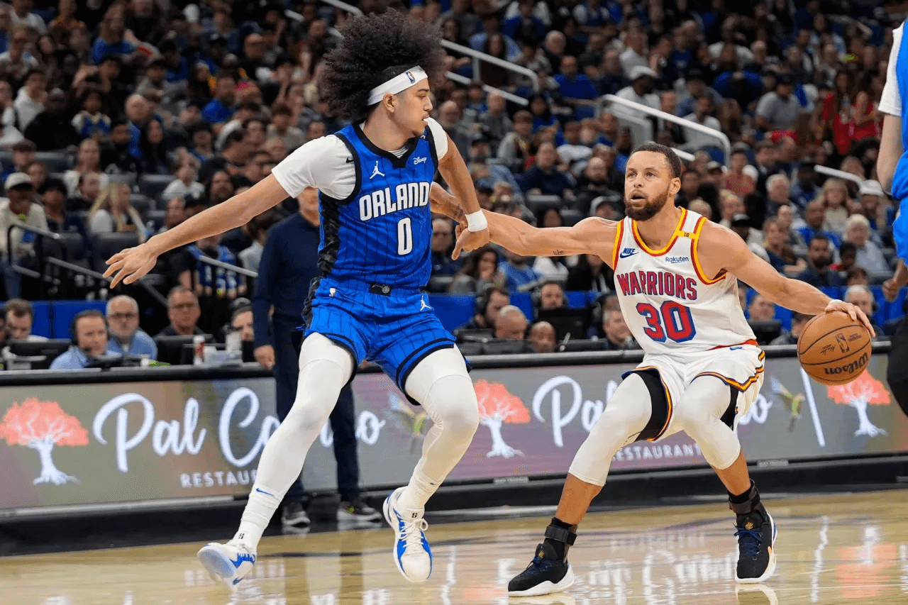 Jogador do Orlando Magic marcando um adversário em jogo da NBA